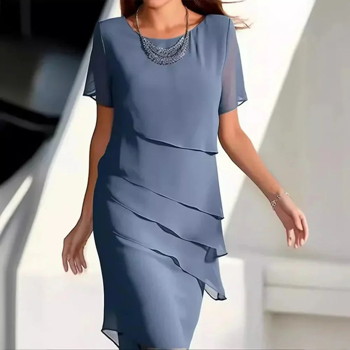 Elegancka damska sukienka midi z warstwowym designem, okrągłym dekoltem i krótkimi rękawami.