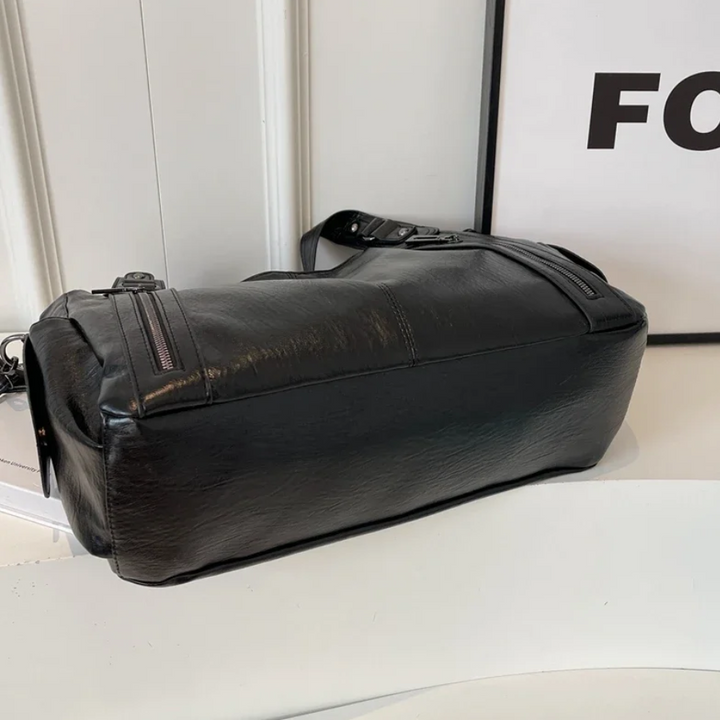Torebka Amber na ramię w kolorze brązowym, wykonana z materiału roślinnego, z paskiem na ramię, metalowymi detalami i kieszeniami, elegancki i przestronny design dla kobiet.