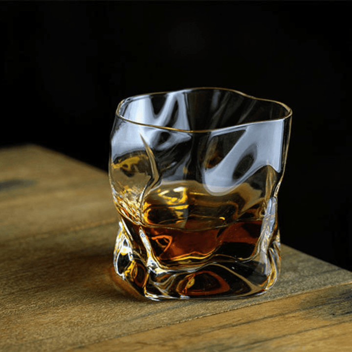 Japońska szklanka do whisky Edo Kiriko o unikalnym designie ze zgniecionej butelki, z grawerowanymi wzorami i nowoczesną estetyką.