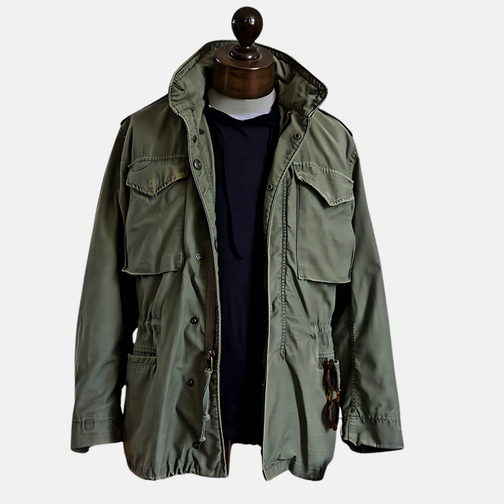 Męska kurtka wojskowa w stylu vintage, kolor zielony, z wysokim kołnierzem, czterema przednimi kieszeniami i regulowaną talią. Styl militarny.